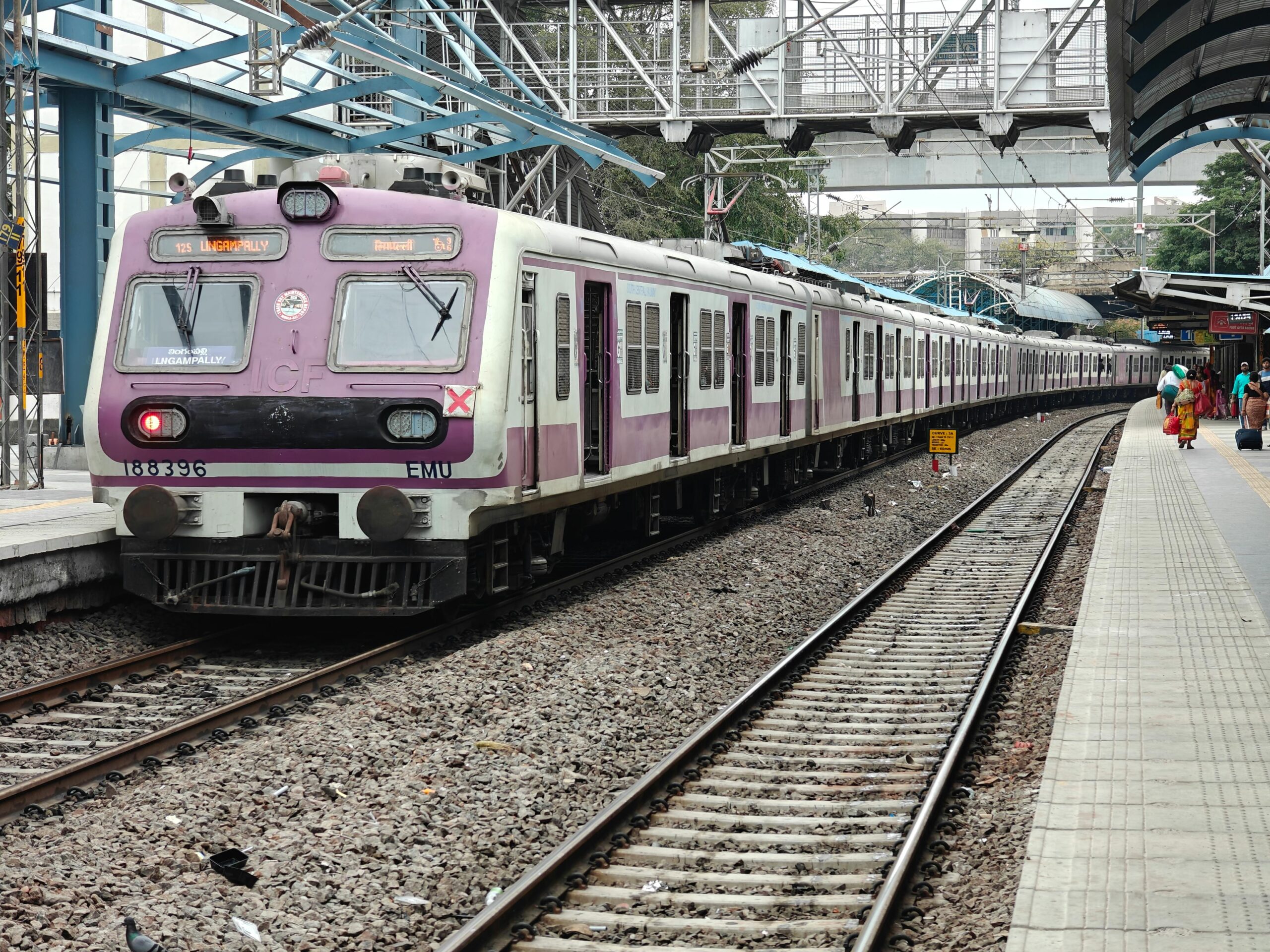 A suburban commuter train stationed at a platform in Hyderabad, India, showcasing urban transport.